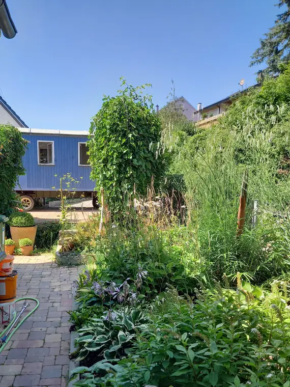 Blick über den Garten auf den Bauwagen Egon